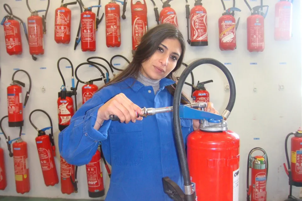 Maintenance d’extincteurs par une technicienne spécialisée
